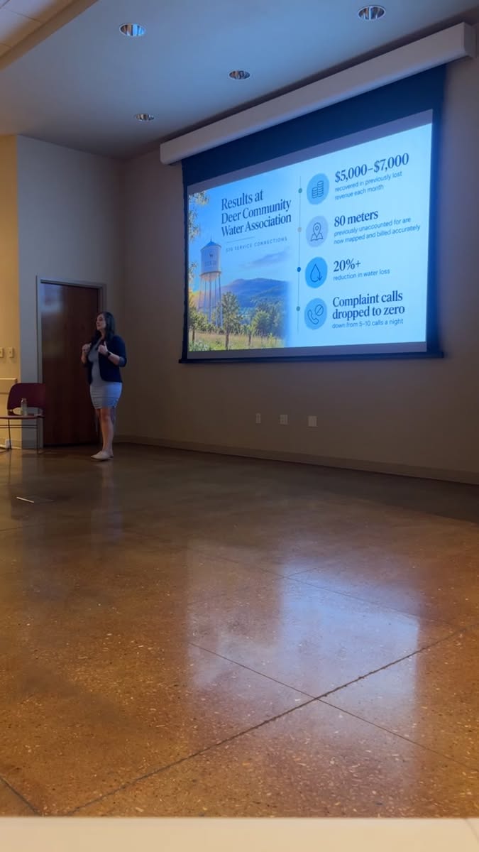 Brie Campbell presenting Innovation in Newton County, with a slide on results at Deer Community Water Association
